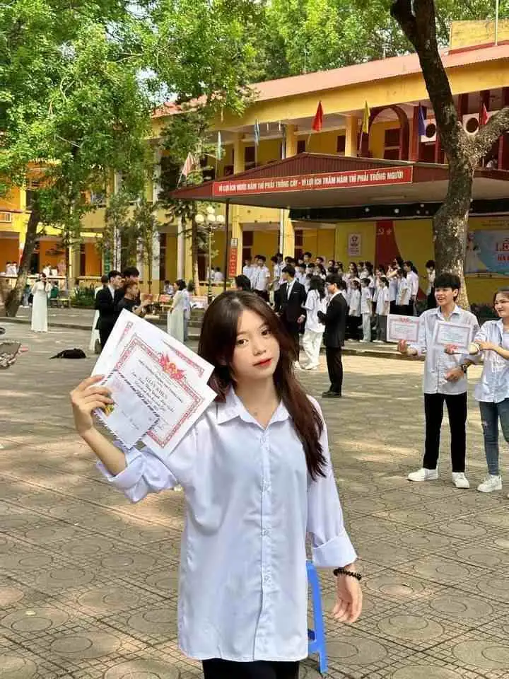 Gái học sinh mặc áo sơ mi trắng cầm giấy khen Gái học sinh mặc áo sơ mi trắng cầm giấy khen