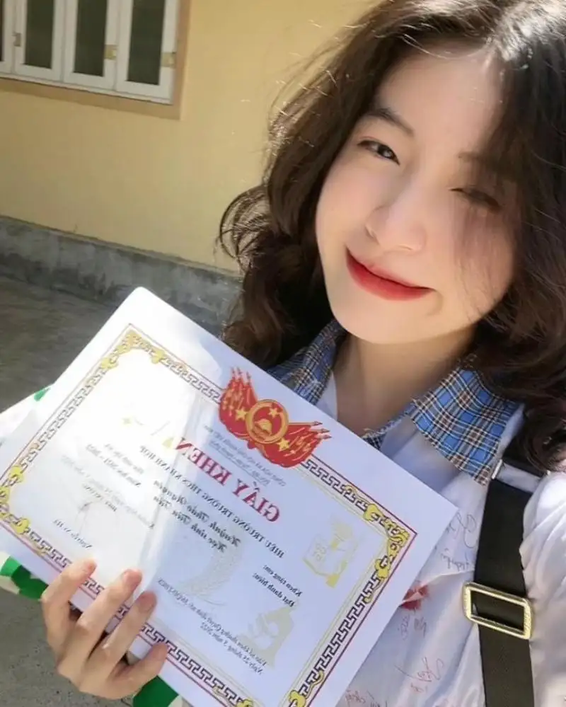 Gái học sinh mặc áo sơ mi trắng cầm giấy khen Gái học sinh mặc áo sơ mi trắng cầm giấy khen