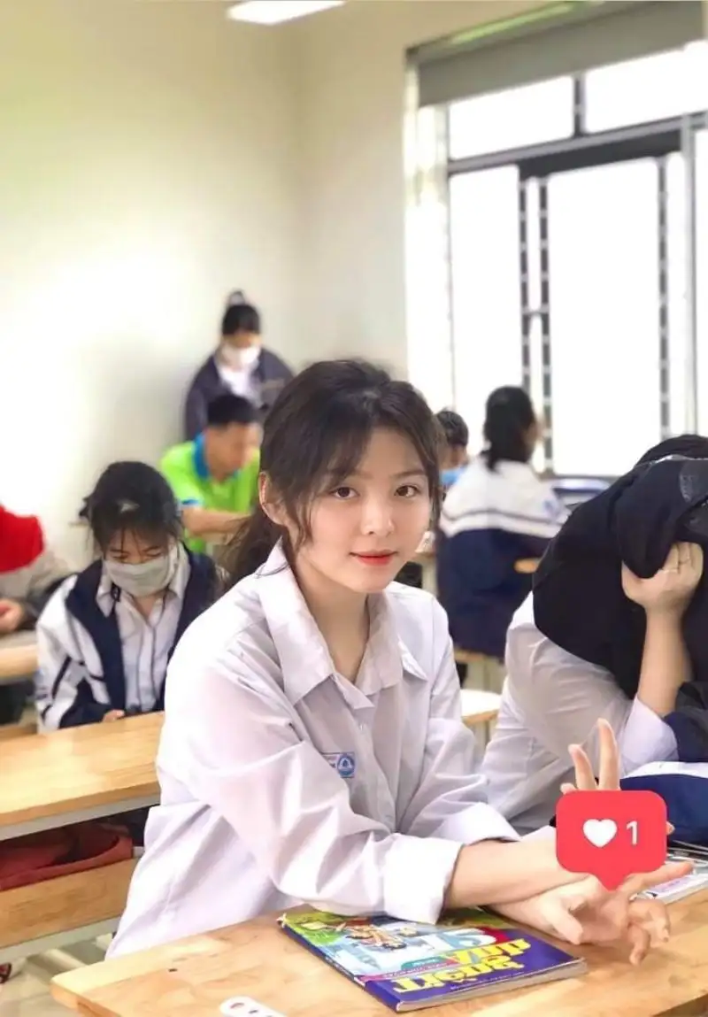 Gái học sinh mặc áo sơ mi trắng ngồi trong lớp học Gái học sinh mặc áo sơ mi trắng ngồi trong lớp học