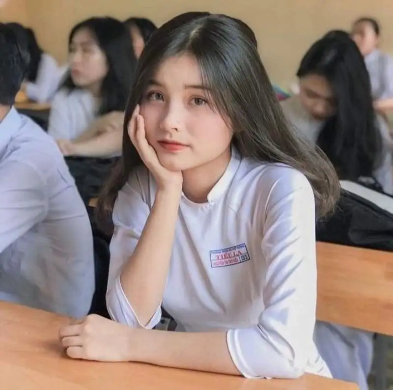 Gái học sinh mặc áo dài trắng ngồi trong lớp học Gái học sinh mặc áo dài trắng ngồi trong lớp học